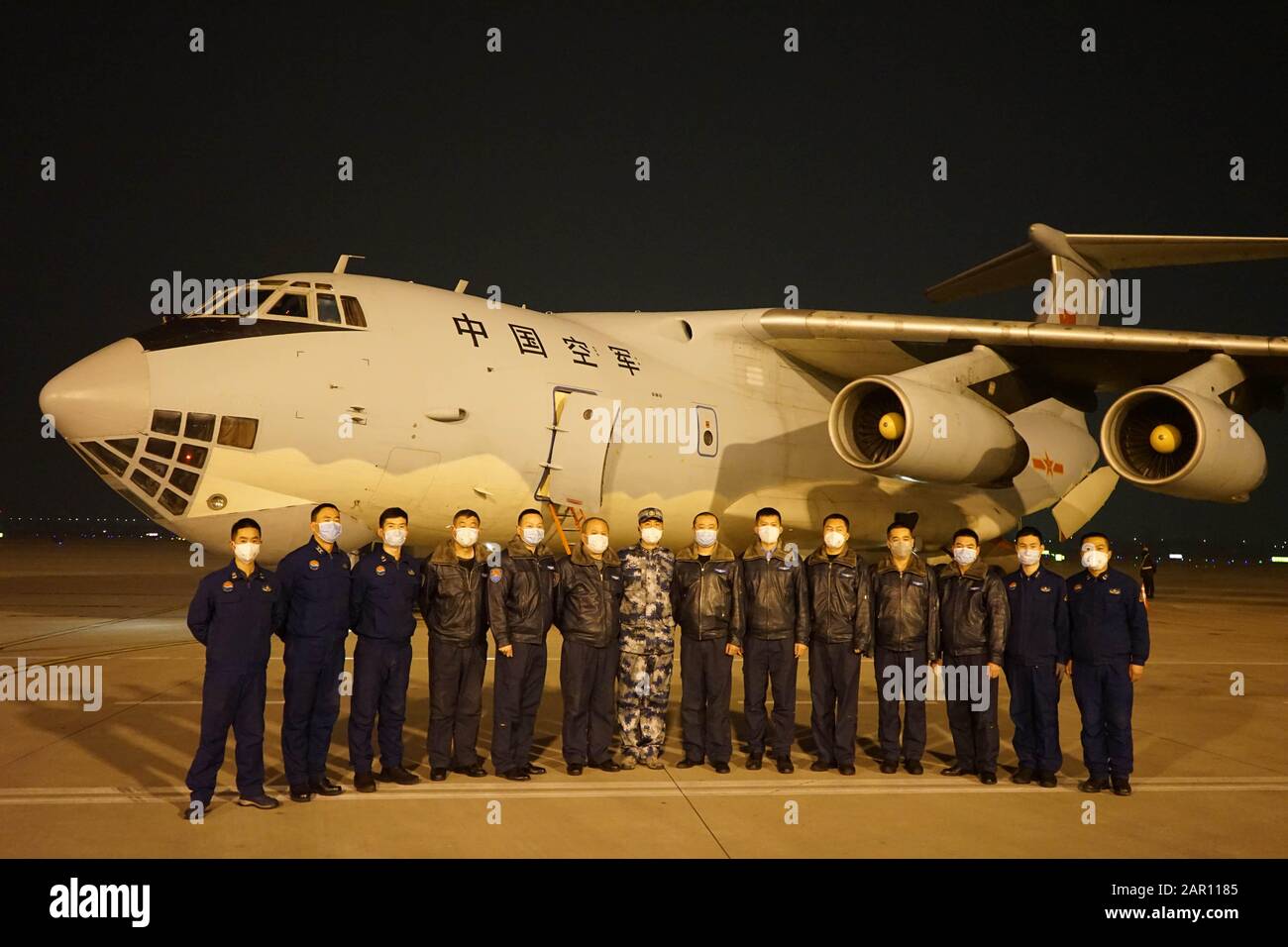 (200125) -- XIANYANG, Jan. 25, 2020 (Xinhua) -- Crew members of a military transport aircraft pose for a group photo at Xi'an Xianyang International Airport in Xi'an, capital of northwest China's Shaanxi Province, Jan. 24, 2020. For providing medical aid, an air force unit accepted a misson to transport a team of medical staff to Wuhan, the center of the novel coronavirus (2019-nCoV) outbreak. (Photo by Li Shining) Stock Photo