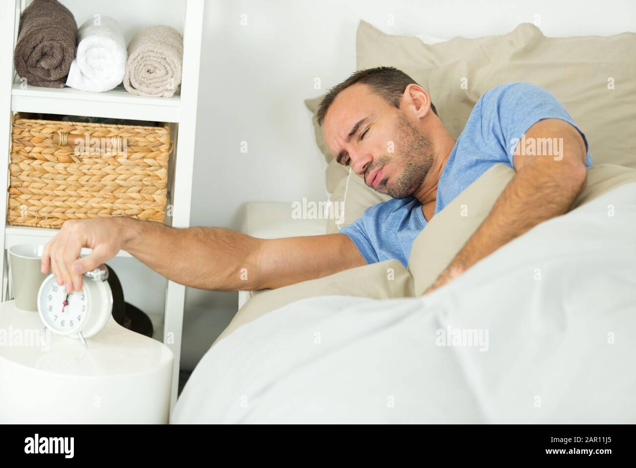 man turns off the alarm clock Stock Photo Alamy
