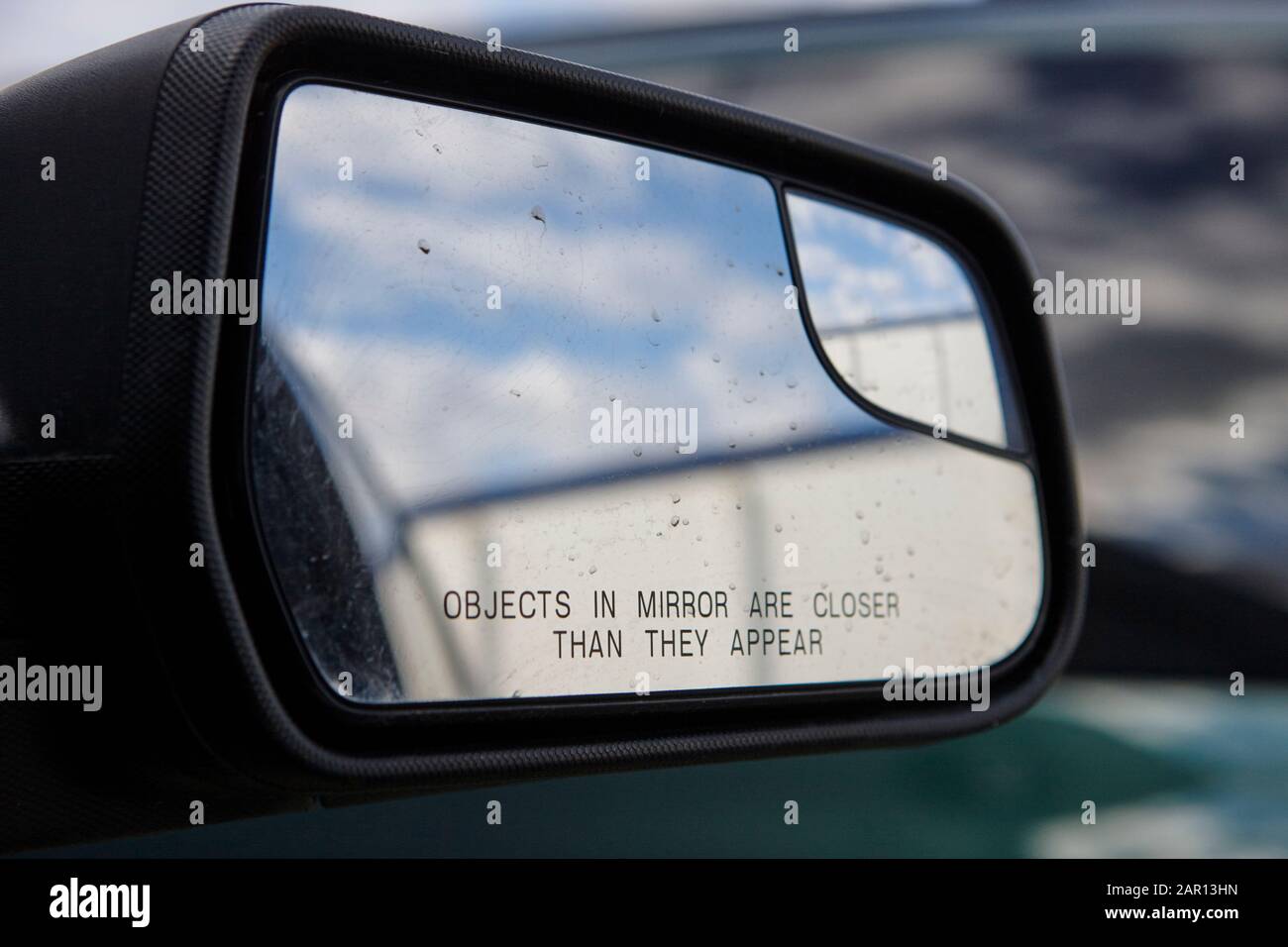 objects in mirror are closer than they appear on car side mirror Stock Photo