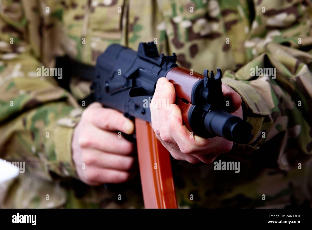 man in combat fatigues holding aks-47u close quarter combat kalasknikov rifle holding in threatening position stance defending Stock Photo
