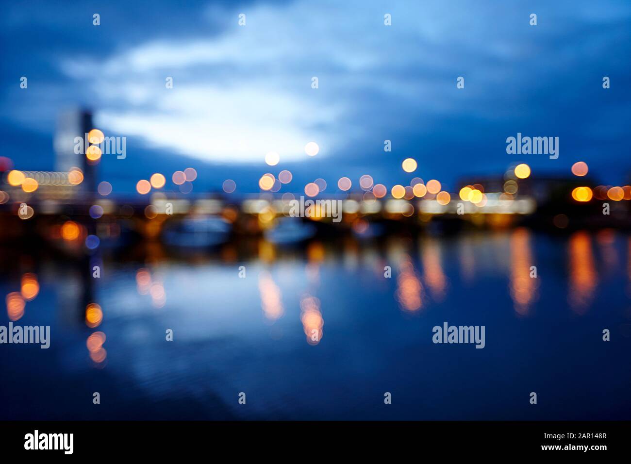 abstract out of focus photograph of queens bridge and river lagan Belfast waterfront at night Northern Ireland concept of evening in a city in the UK Stock Photo