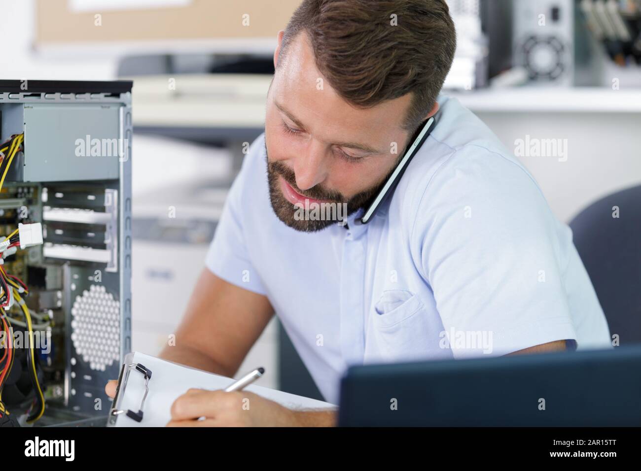 computer engineer on the phone repairing broken desktop Stock Photo - Alamy