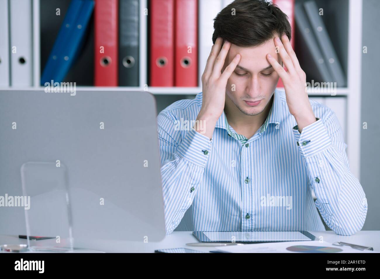 Businessman sitting in a stressful situation in the office. Hold your