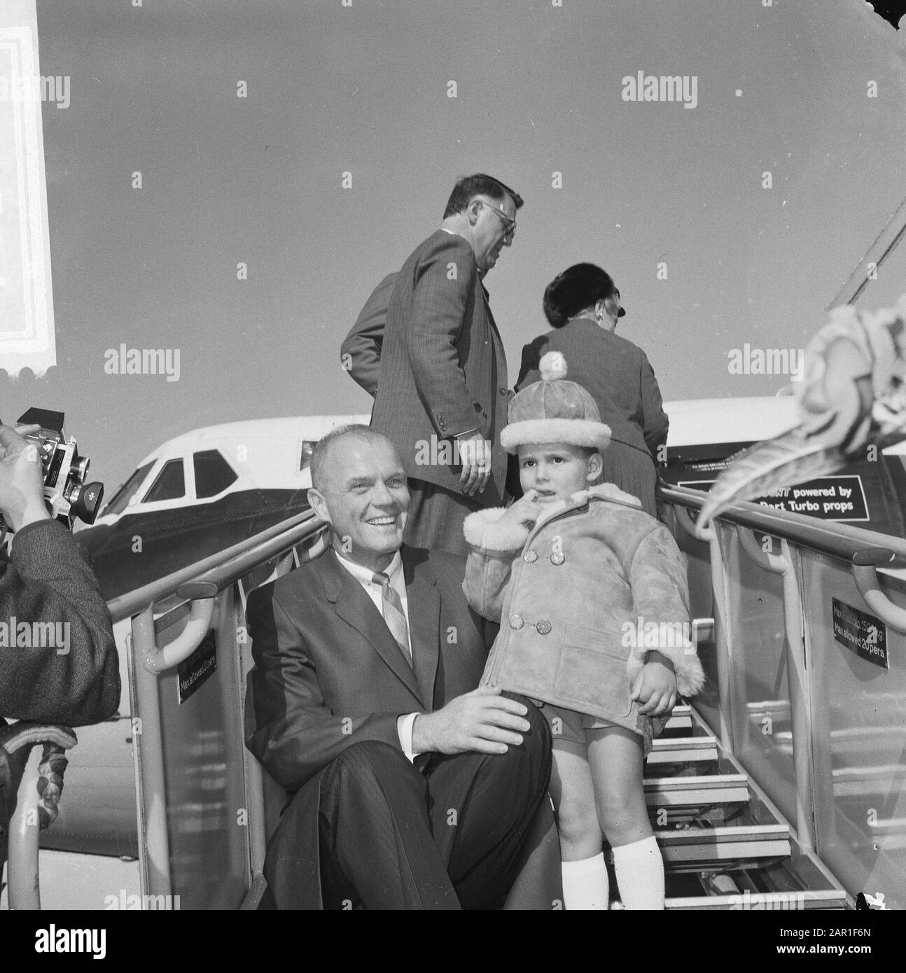 Visit to the Netherlands by astronaut John Glenn and his family  John Glenn sitting on the plane stairs in the company of his son Date: 9 October 1965 Location: Noord-Holland, Schiphol Keywords: visits, spacecraft Personal name: Glenn, John H. Stock Photo