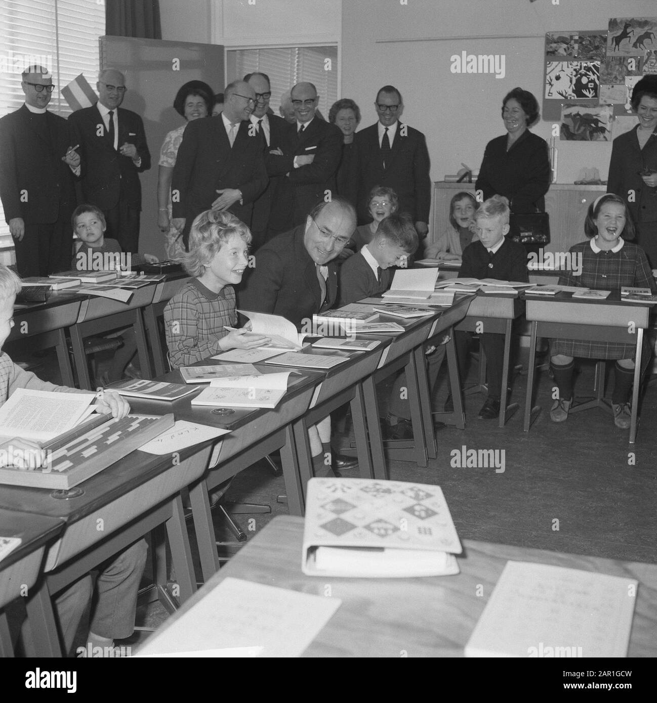 Minister-President Cals during the opening of the Mr. Calsschool in Rotterdam  Prime Minister Cals sitting behind a table, next to a student Date: 27 October 1965 Location: Rotterdam, South Holland Keywords: pupils, ministers-presidents, openings, schools Personal name: Cals, Jo Stock Photo