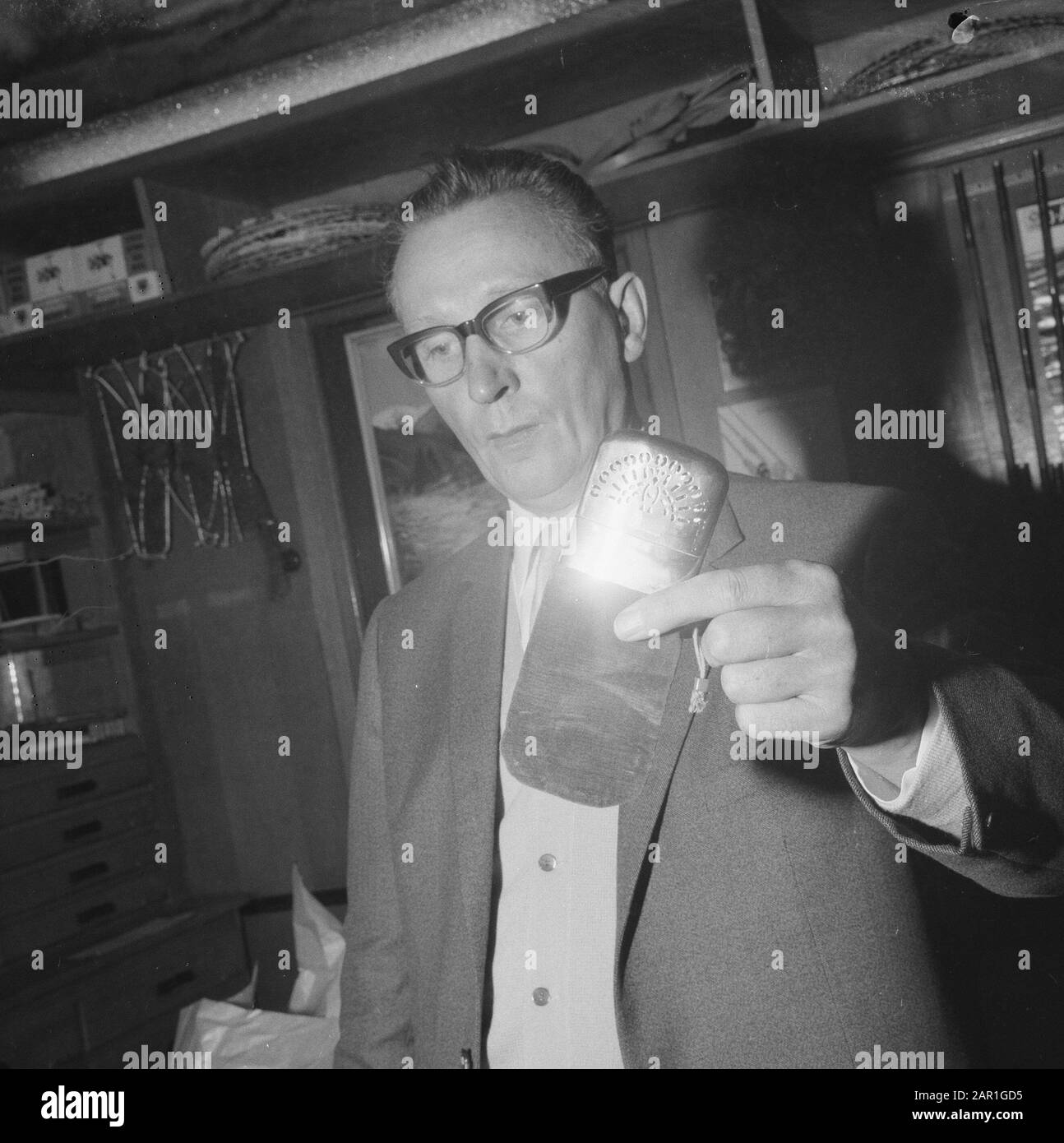 Man demonstrating the Peacock Pocket Warmer, a hand warmer for people who are cold on the football field or fishing  cold, heat, sports goods Date: 28 October 1965 Keywords: cold, sports goods, heat Stock Photo