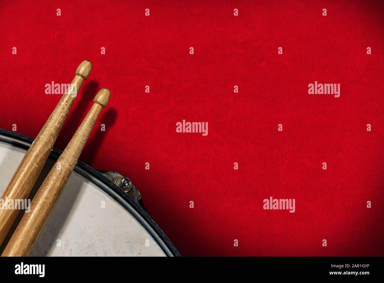 Close-up of two wooden drumsticks and an old metallic snare drum on a ...
