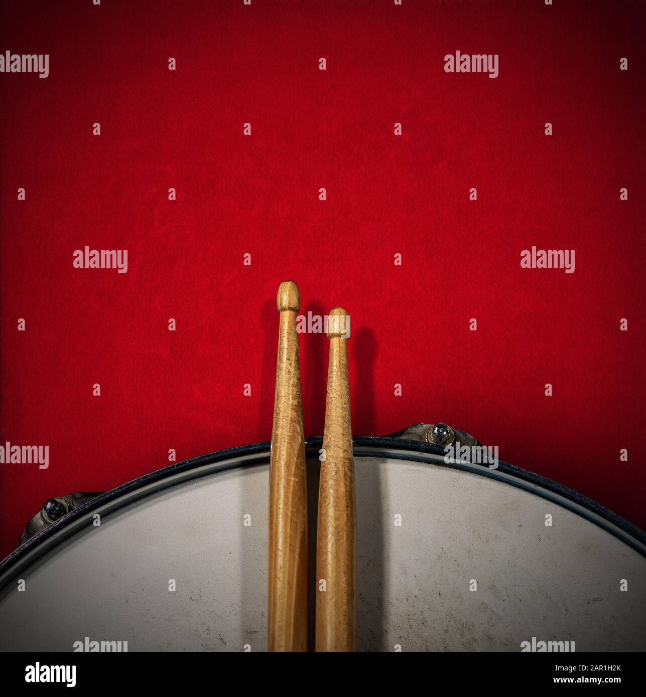 Close-up of two wooden drumsticks and an old metallic snare drum on a ...