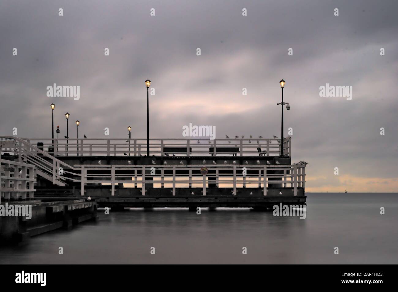 Footbridge at sea at sunrise Stock Photo