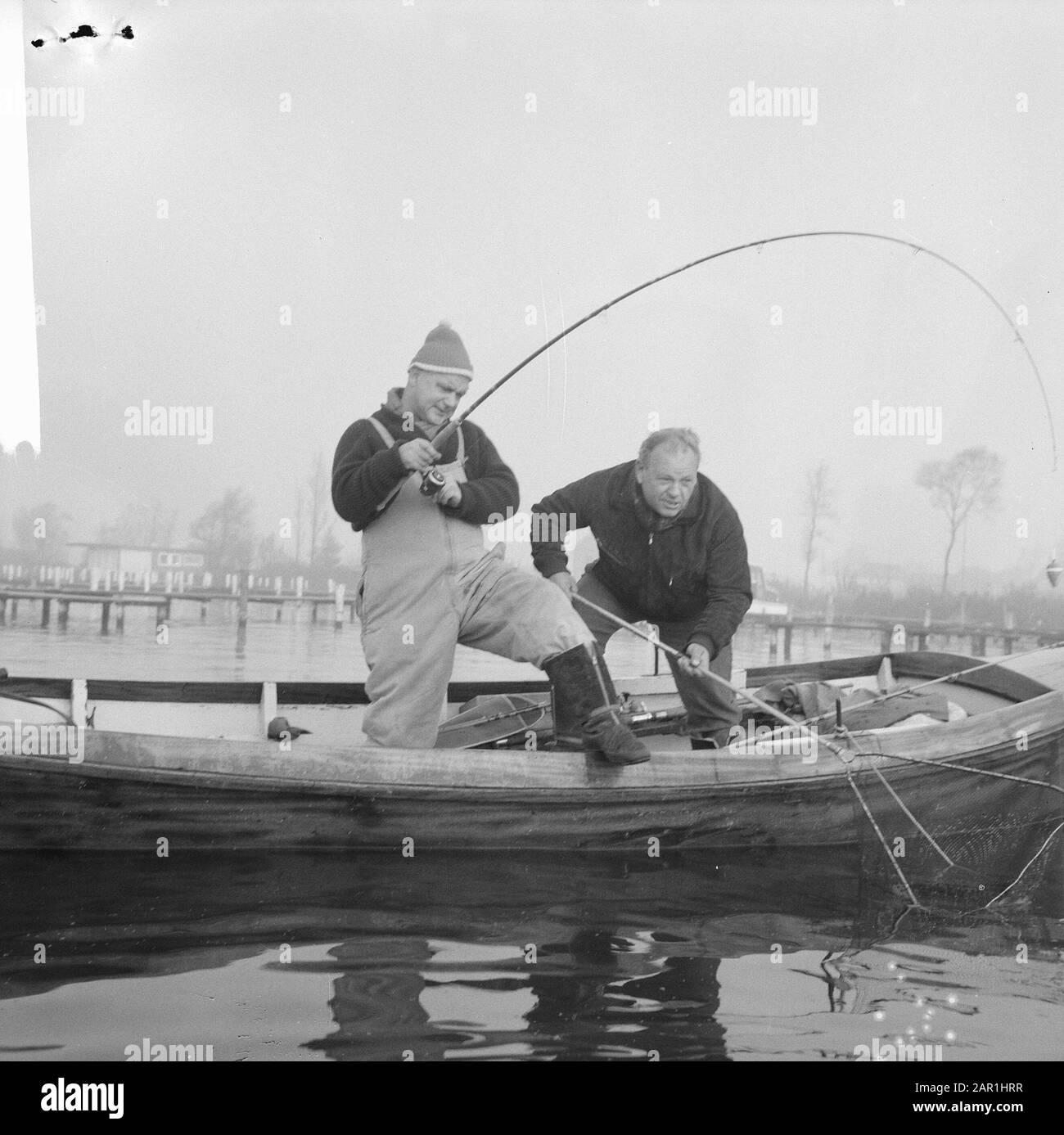Fishermen exercising their hobby  Two men while fishing standing from a boat Date: 14 November 1965 Keywords: fishing, motor boats Stock Photo