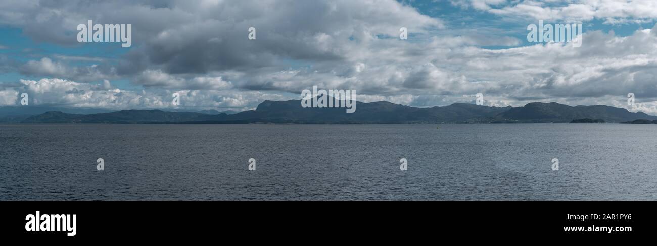 Panoramic view of a cloudy fjord with a mountain ridge in the background on a summer day, Norway Stock Photo