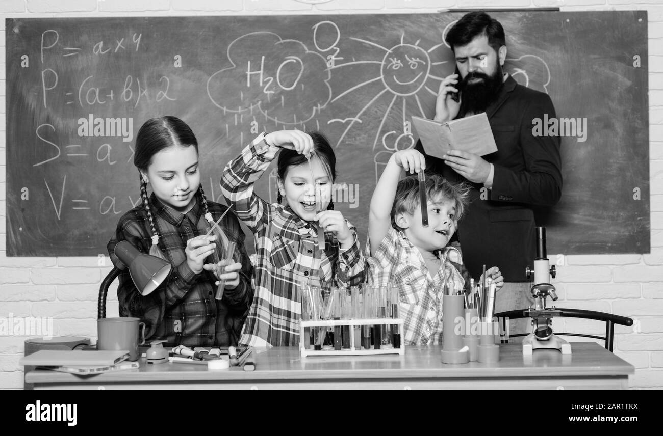 In search of right medical solution. back to school. kids in lab coat learning chemistry in school laboratory. chemistry lab. making experiment in lab or chemical cabinet. happy children teacher. Stock Photo