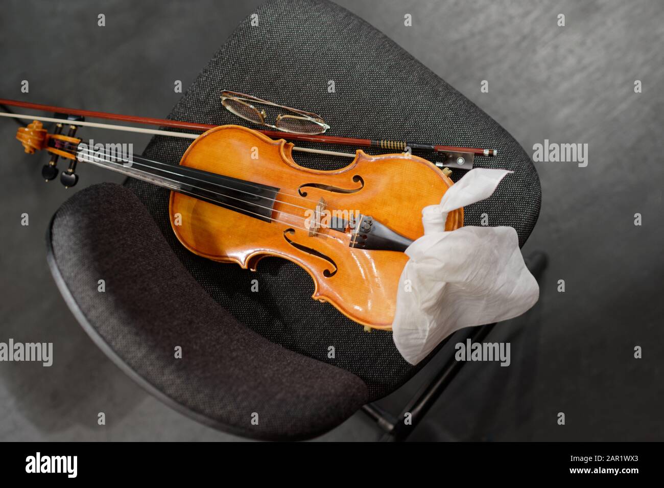 Musical instruments: violin and bow on the musician's chair Stock Photo