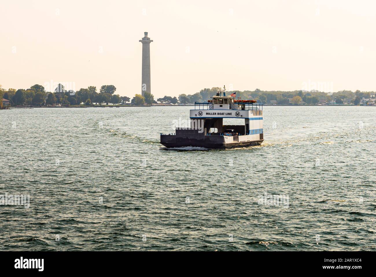 Ferry carrying cars and people from Put-in-Bay Ohio with Perry's Monument in the background Stock Photo