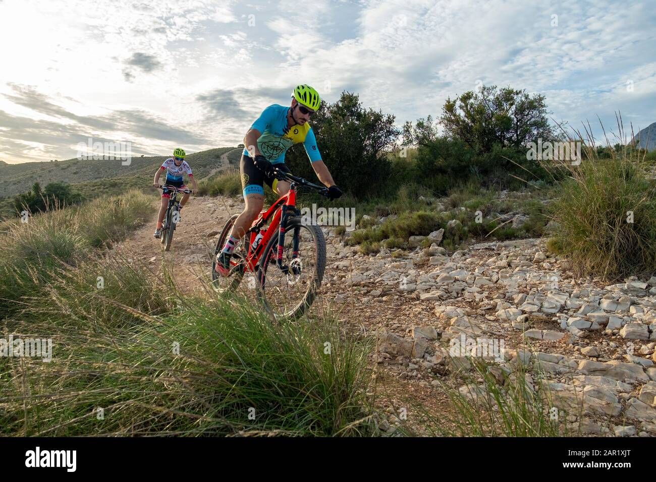 Two mountain bikers riding on hill , Sierra Cortina, Benidorm, Alicante province, Spain Stock Photo