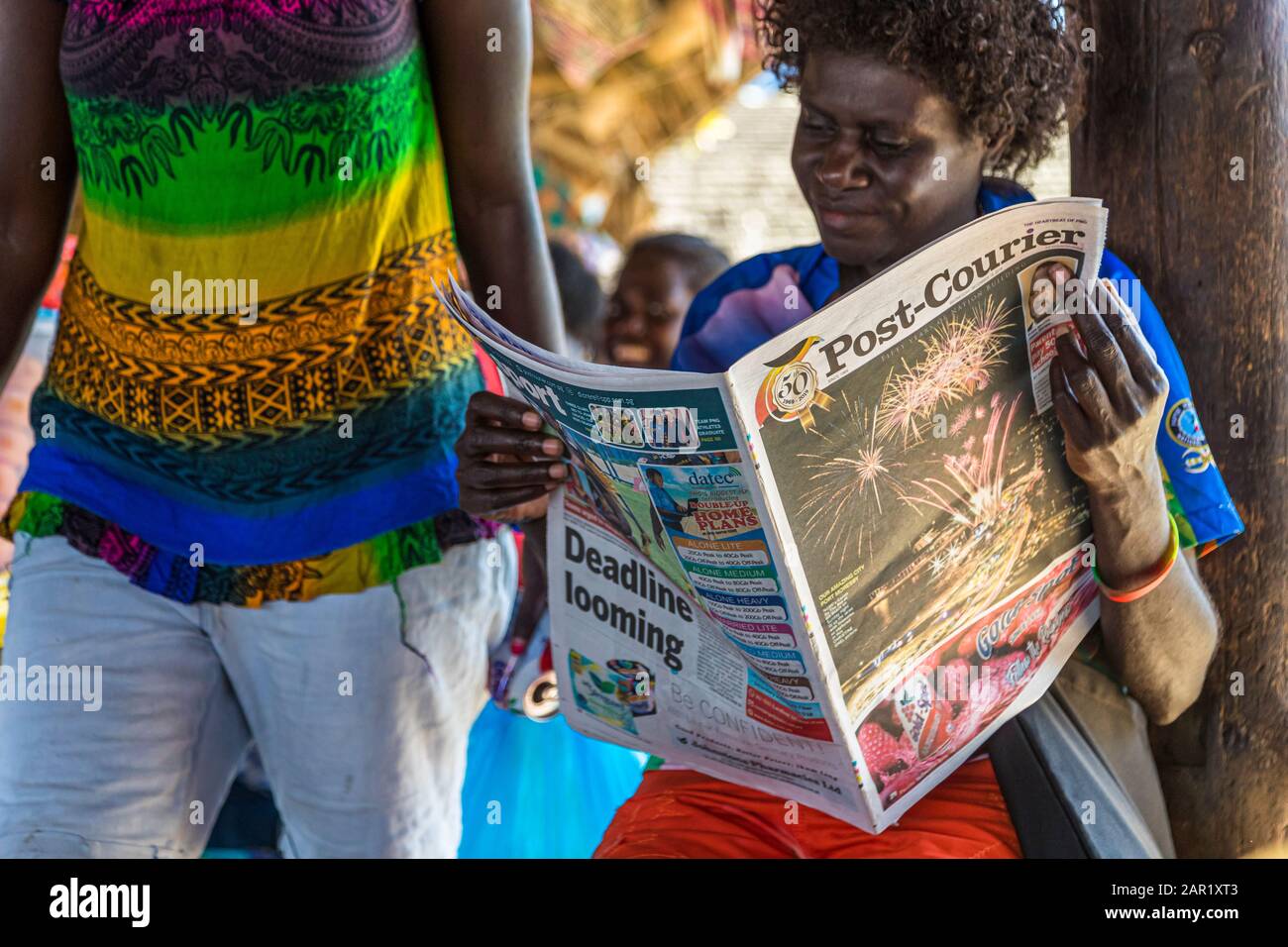 Female Newspaper-Reader in Bougainville, Papua New Guinea Stock Photo