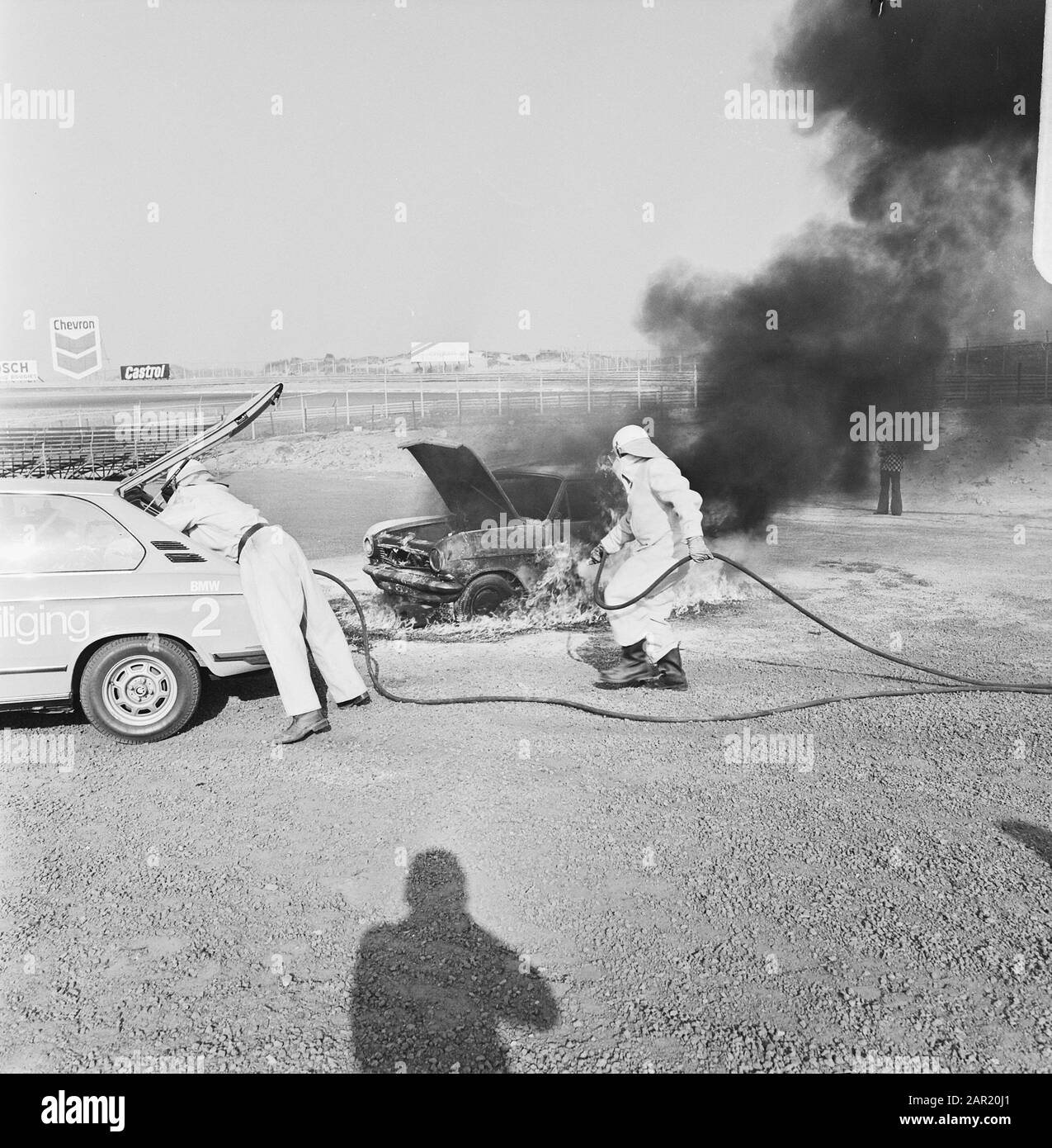 Rescue demonstration at Zandvoort circuit, volunteers with equipped BMW extinguishing fires wreck Date: 9 april 1974 Location: Noord-Holland, Zandvoort Keywords: VOLUNTERS, demonstrations Stock Photo