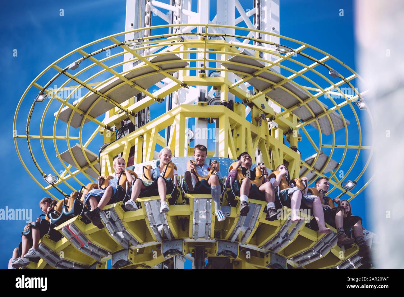 MUNICH, GERMANY - Sep 29, 2019: Happy kids poeple sitting in free fall tower smilling at bavarian munich Oktoberfest with traditional clothing Stock Photo