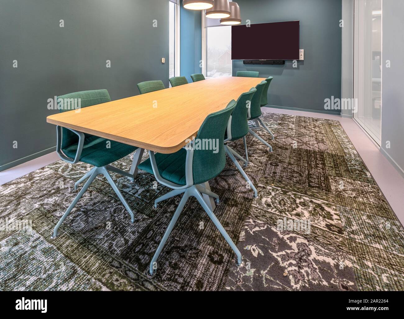 Chairs put next to a table in a room with a patterned carpet Stock Photo