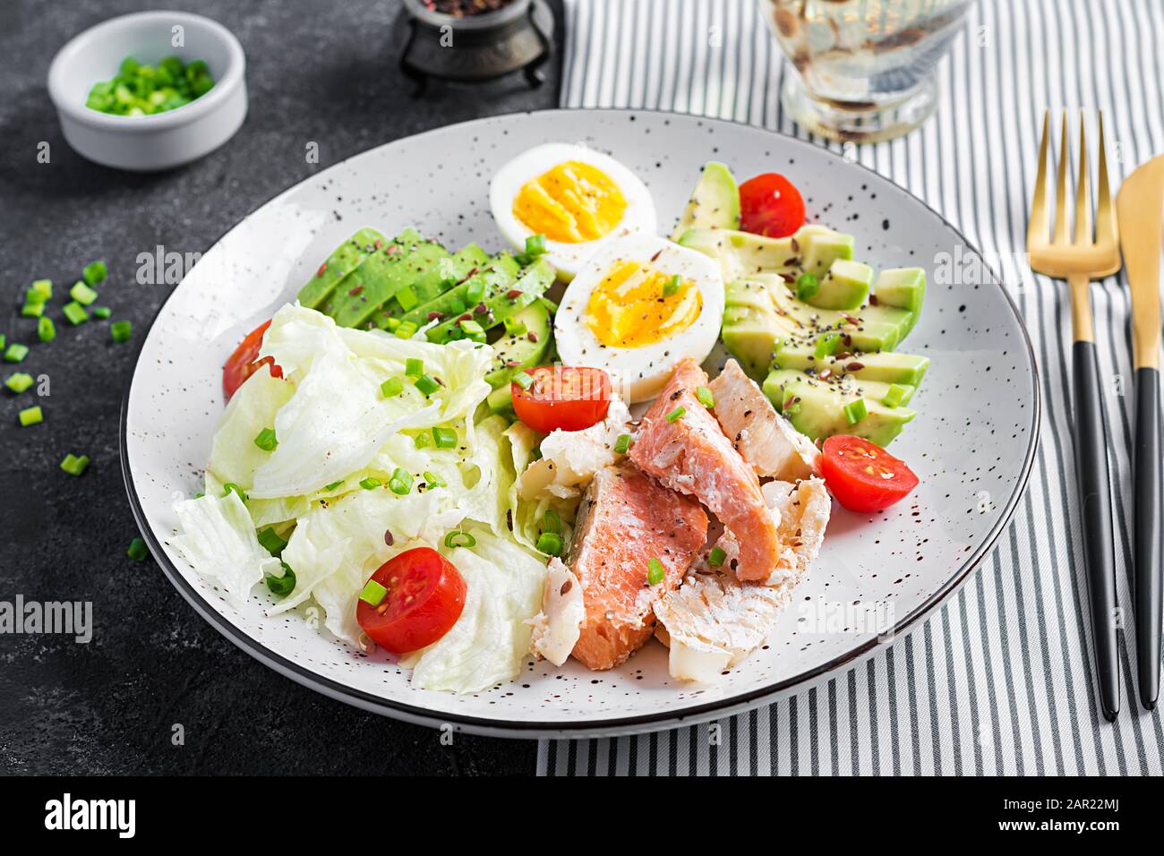 Ketogenic diet breakfast. Eggs, fish and avocado, lettuce and seeds