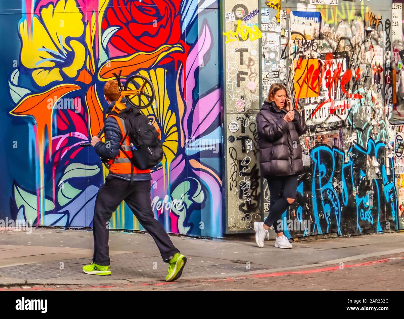 Grafitti on the street with passers-by Stock Photo