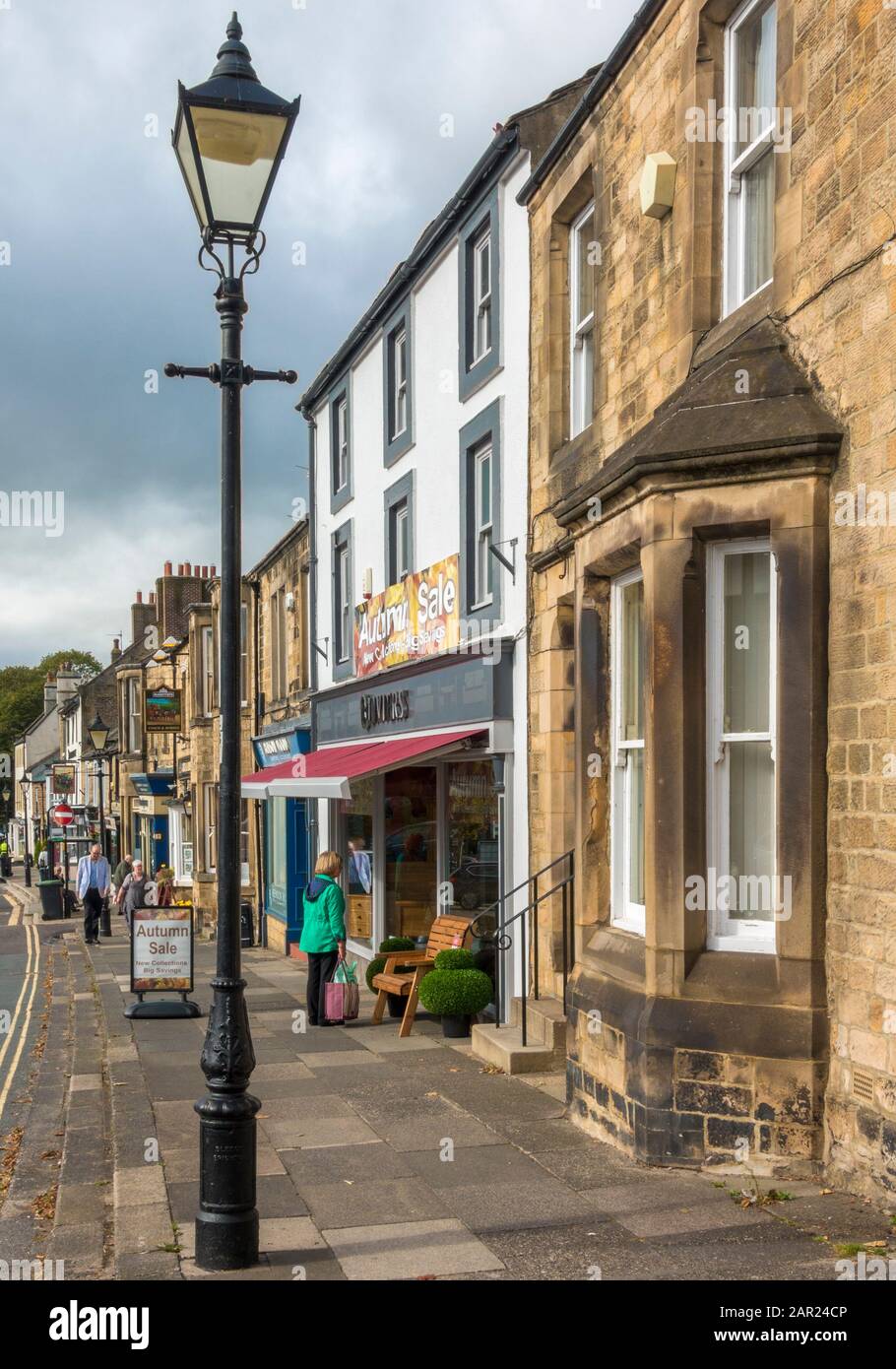 Period shops and buildings with people, on one side of Galgate, in the historic market town of