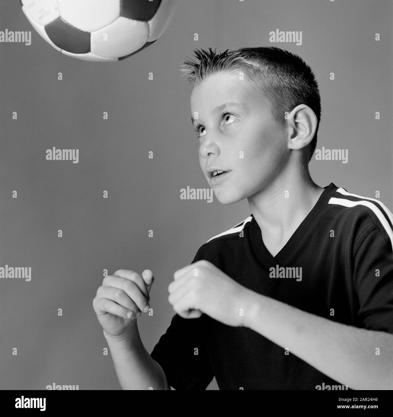Children. Sport. Close up of boy heading a football. Stock Photo