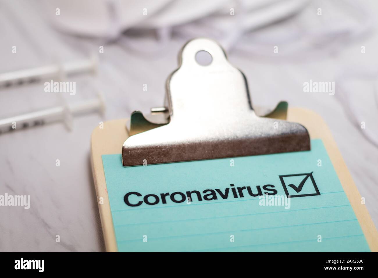 Coronavirus 2019-nCOV medical still life concept on clipboard with mask and needles Stock Photo