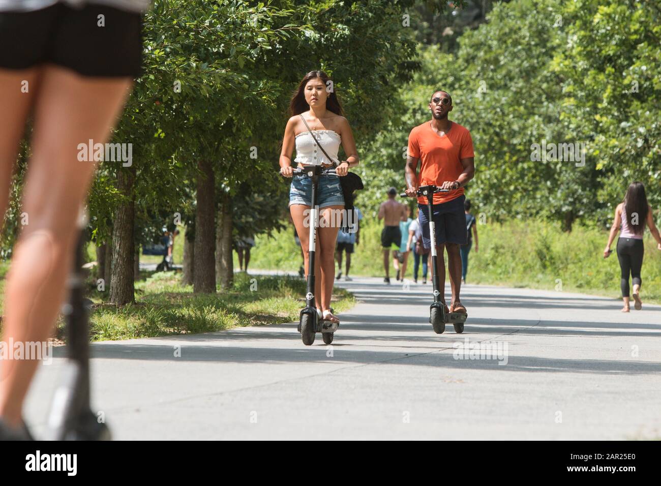 People ride motorized scooters along the Atlanta Belt Line at the Old