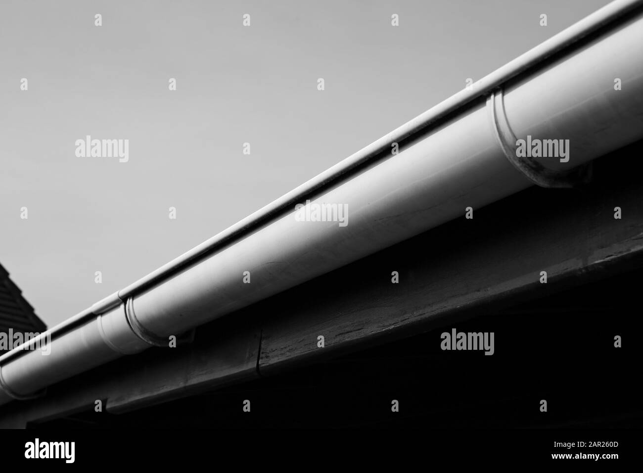 Grey scale low angle shot of a white pipe on a wooden board Stock Photo