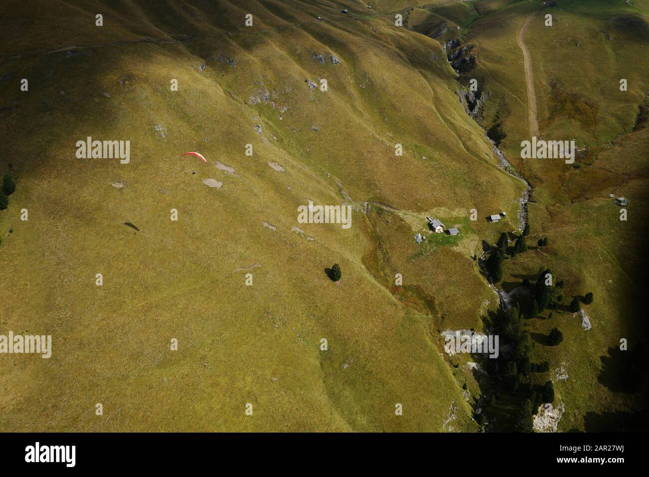 Aerial view of paragliding pilot flying in the Dolomites. Stock Photo