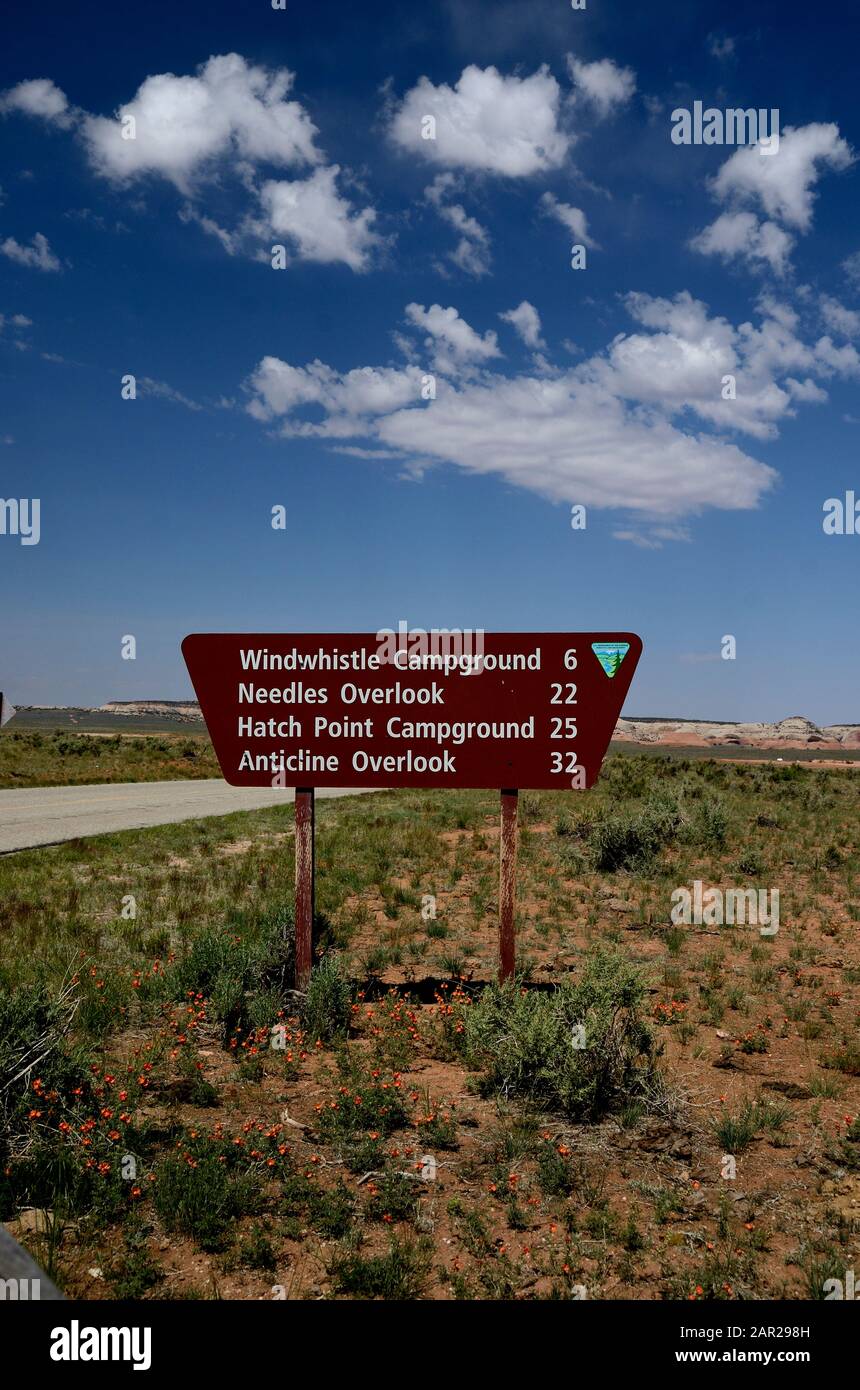 brown road sign indicating the distance to different destinations, in the background blue sky with white clouds. Stock Photo