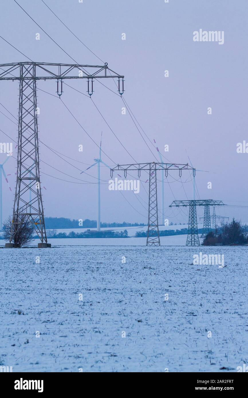 electric power lines with wind turbines in winter landscape, germany, thuringia, jena Stock Photo