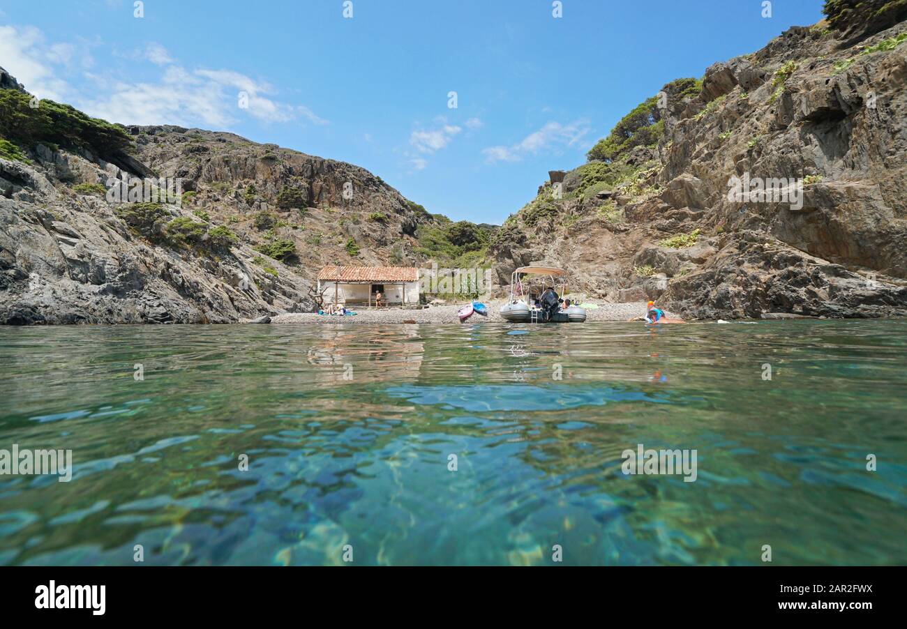 Mediterranean sea, small rocky beach with a hut (old refuge for fishermen), seen from water surface, Spain, Costa Brava, Cap de Creus, Catalonia Stock Photo