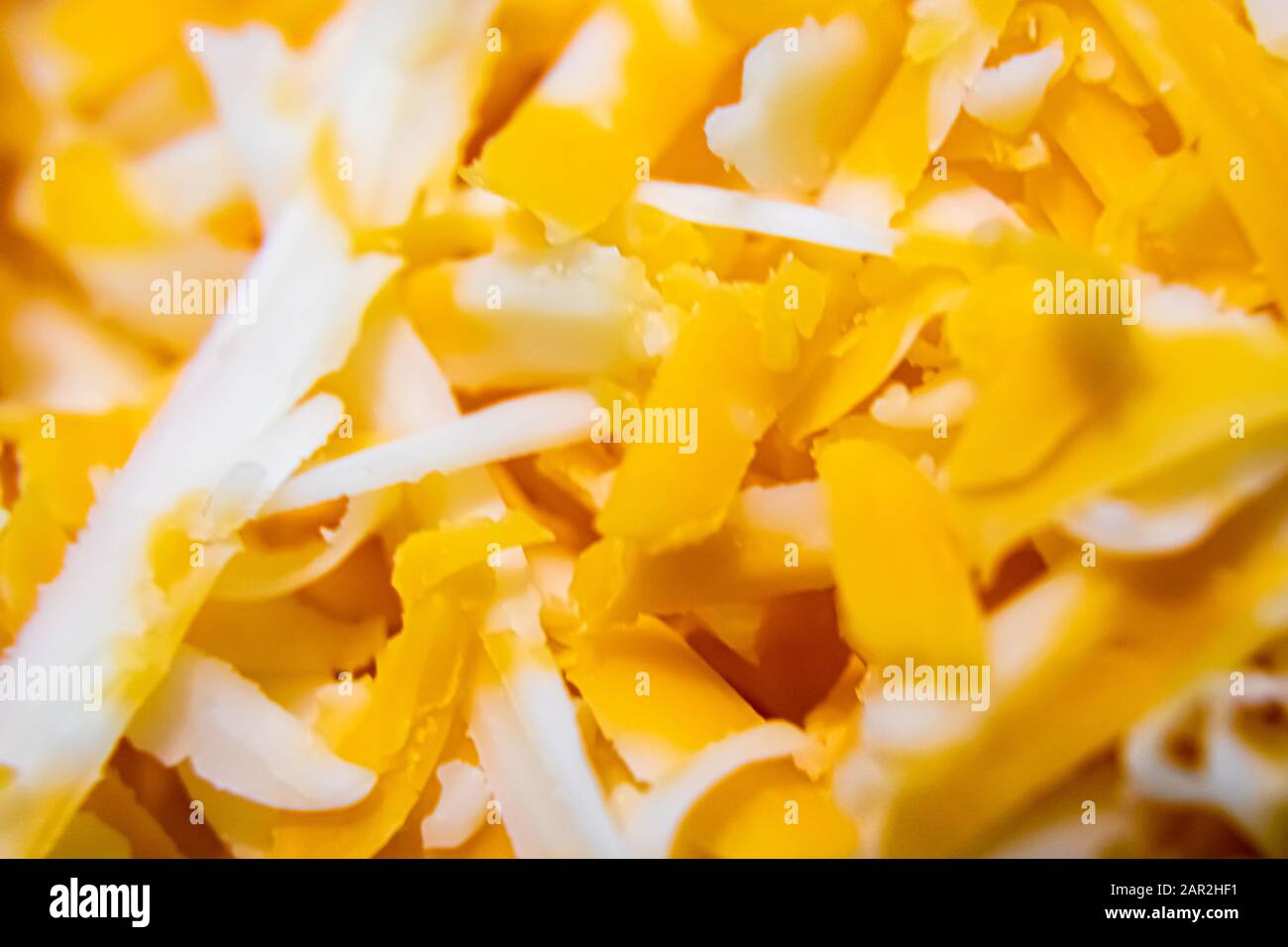 A close-up view of shredded farmer's marble cheddar cheese, showing the  detail and color of the food Stock Photo - Alamy