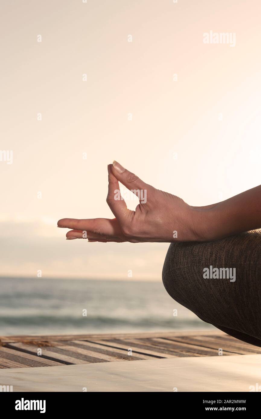 woman doing yoga in beautiful nature background at sunset or sunrise, mindfulness and relaxation concept. Stock Photo