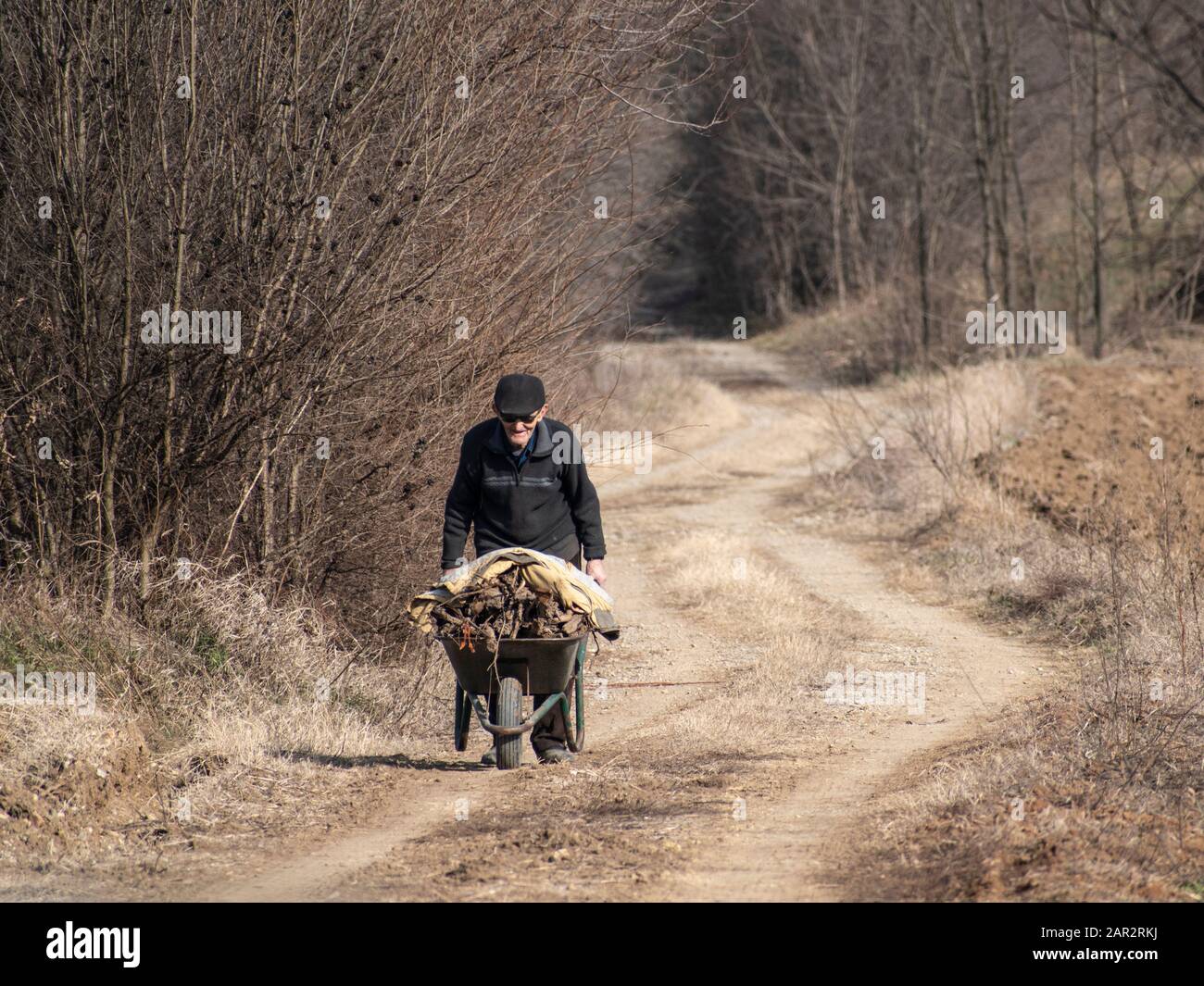 Man pushing wheel barrow hi-res stock photography and images - Alamy