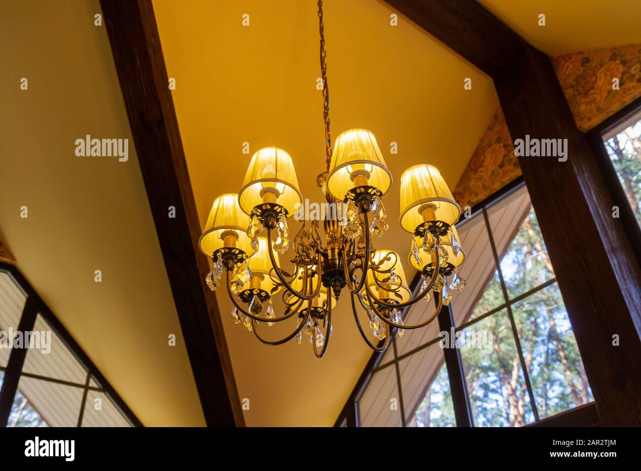 chandelier with a pleasant light shines in a wooden house Stock Photo