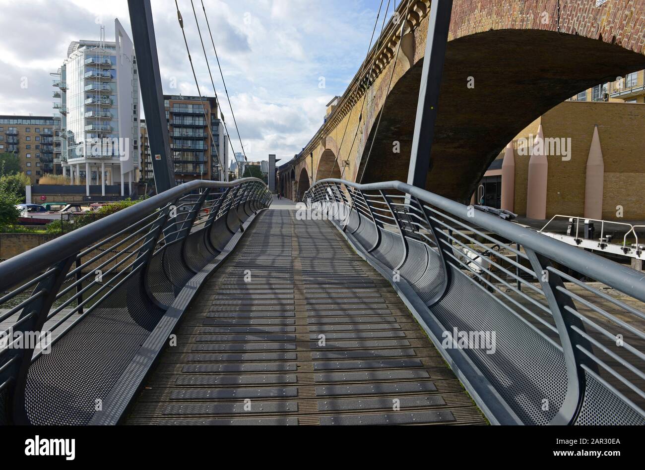 Modern wooden slatted pedestrian bridge at Limehouse Basin in eastern
