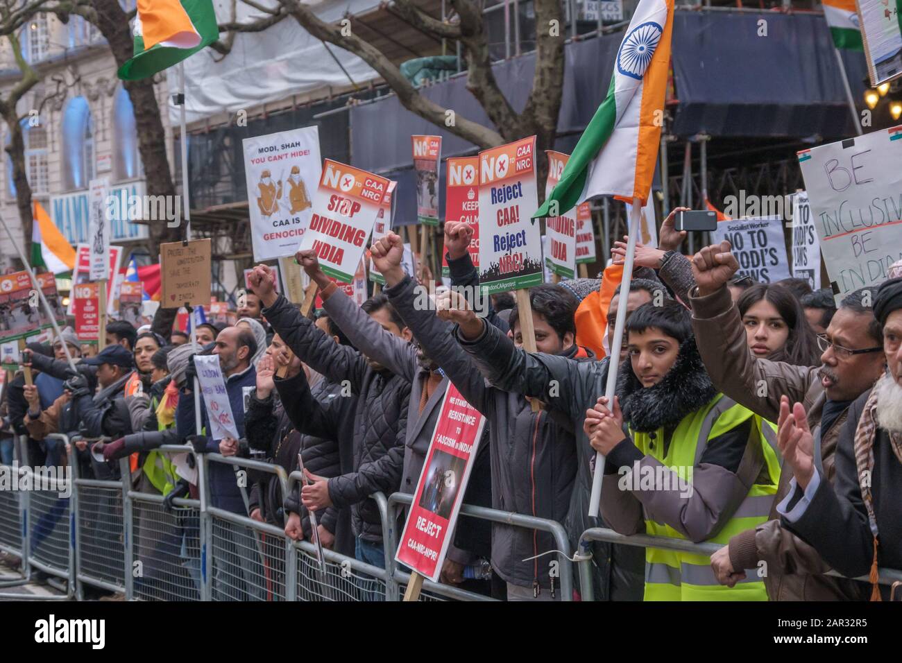 London, UK. 25th January 2020. People  behind barriers opposite the Indian High Commission raise their fists after singing the Indian National Anthem. They call for India to respect its secular constitution which calls for justice, liberty, equality and fraternity at the end of the protest against the Citizenship (Amendment) Act of the Hindu fascist Modi regime which has prompted horrific state and far-right violence with Muslim neighbourhoods and homes have been invaded by the police and fascist mobs, young men murdered, women, children and elderly people beaten up and tortured and property d Stock Photo