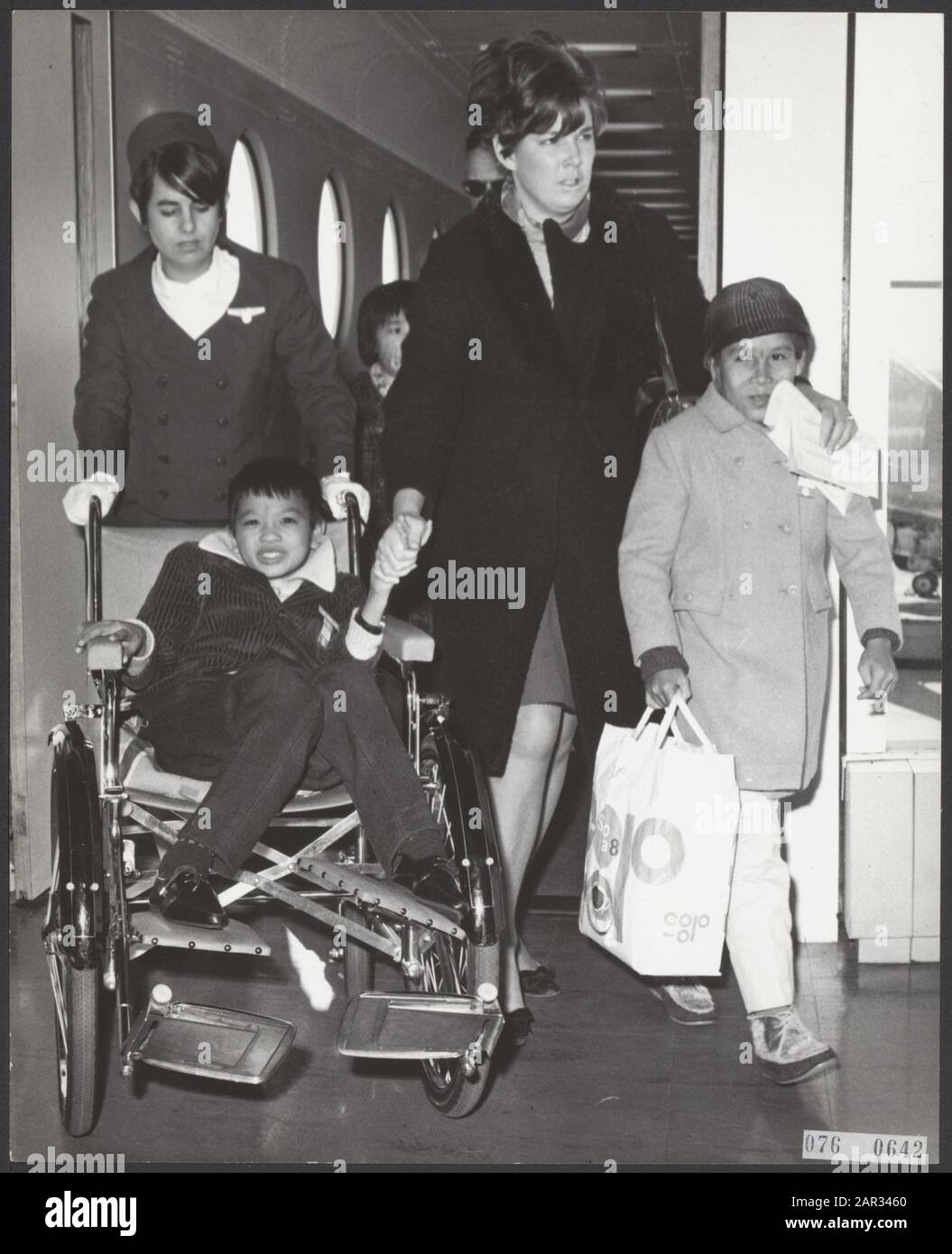 Three children from Vietnam arrived at Schiphol Airport who were seriously injured there by the war. The children, two girls and a boy, were brought to the Netherlands by the foundation Terre des Hommes. His are going to a clinic in Huizen (N.H.). Two of the three children on arrival at Schiphol Airport, in the chair the boy (wounded by mine explosion) and on the right a girl (burns) Date: 27 February 1968 Location: Noord-Holland, Schiphol Keywords: injured, health care, children, airports Stock Photo