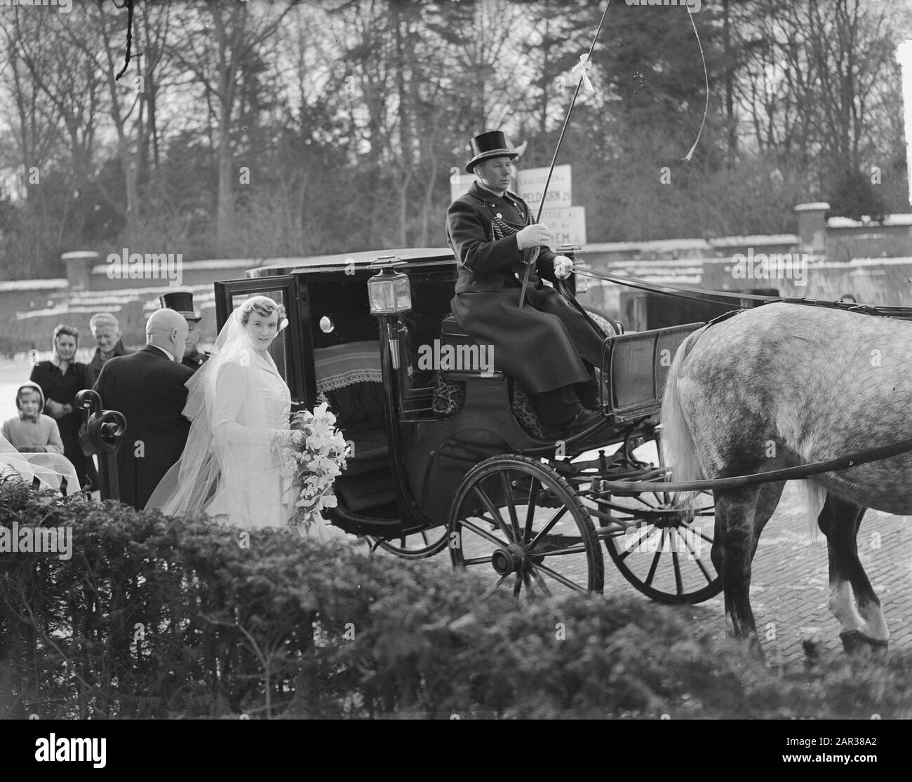 Marriage of Mr. Hans Smulders with Mary Sevenstern at Dieren. The bride in the company of her father at the carriage (Hogestraat in Dieren) Annotation: J.P.M.A. Smulders (1912-) was a member of the management Anefo. Mary Sevenstern was a daughter of the owner of the distillery Sevenstern at Dieren Date: 4 January 1951 Location: Animal Keywords: brides, marriages, carriages Personal name: Sevenstern, M. Stock Photo