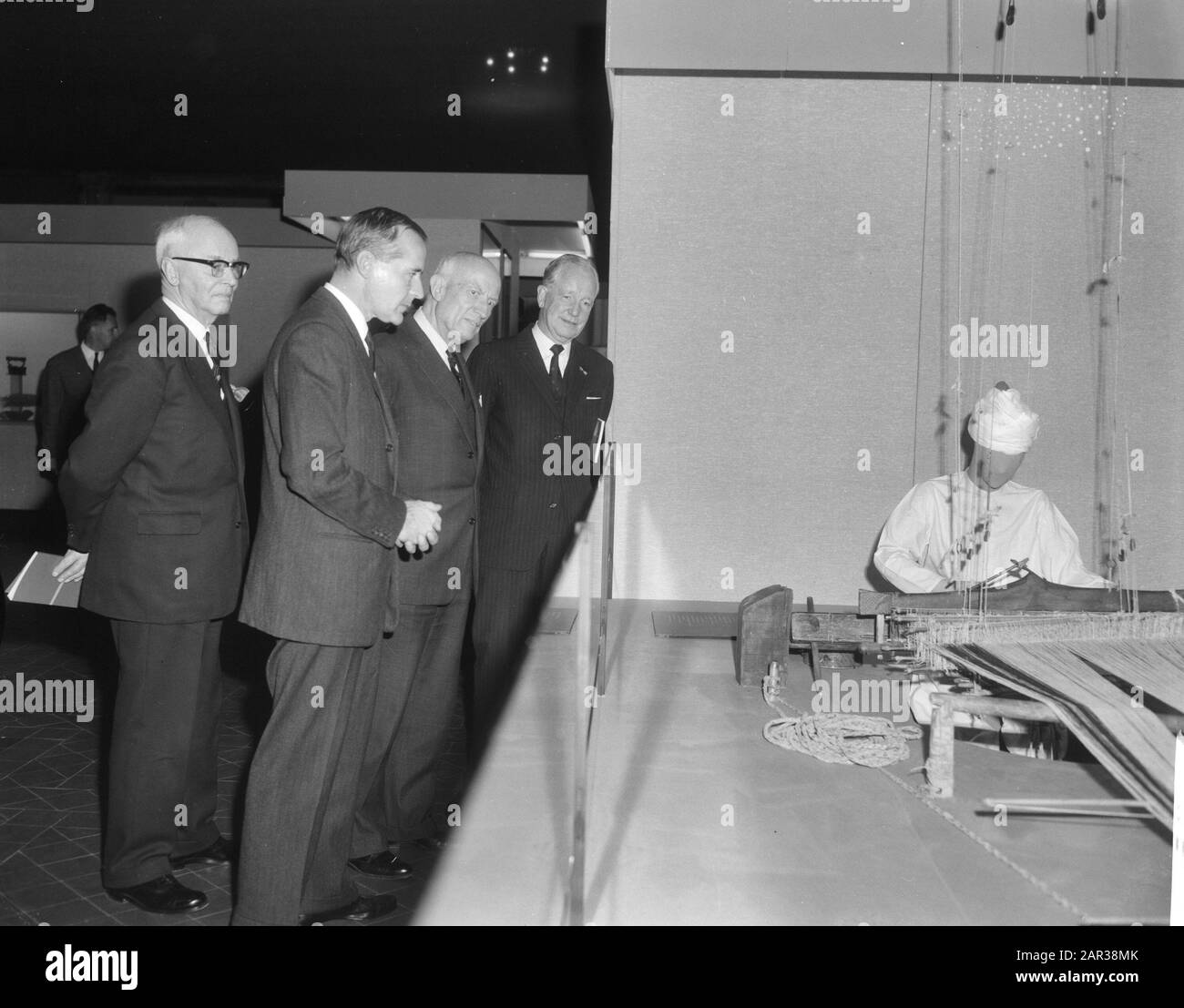 Opening of an exhibition on the Wah, an agricultural community in Pakistan, at the Royal Institute for the Tropics by Alderman Carriage in Amsterdam  Alderman Carriage in the company of a number of men while viewing one of the setups Date: 25 November 1965 Location: Amsterdam, Noord-Holland Keywords: populations, exhibitions, weaving Personal name: Carriage, P.J. Stock Photo