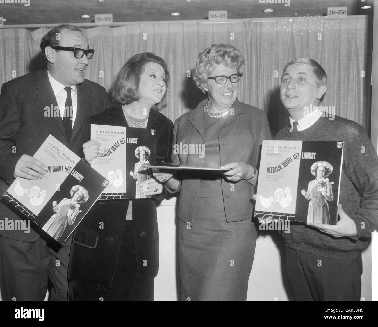 Long playing record of the musical 'Delicious lasts the longest 'by Annie M.G. Schmidt and Harry Bannink awarded to the employees: v.l.n.r.: André van den Heuvel, Conny Stuart, Annie M.G. Schmidt and Leen Jongewaardt Date: 30 November 1965 Keywords: actors, long play records, musicals, music, writers Personal name: Heuvel, Aad van den, Heuvel, André van den, Jongewaard, Leen, Schmidt, Annie M.G., Stuart, Conny Stock Photo