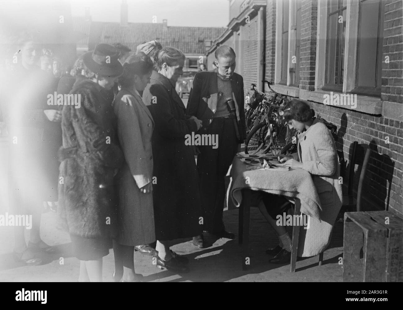 Purges Doesburg Woman behind table does administrative operations. Man