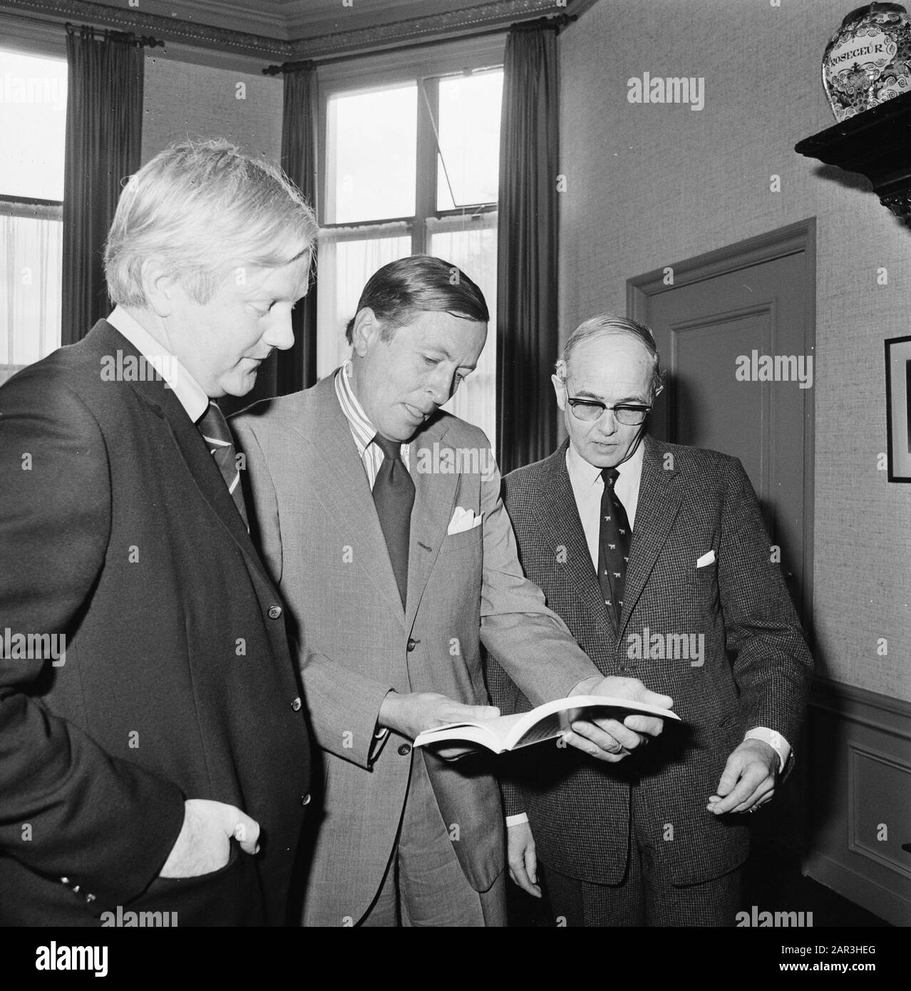 Prince Claus gets a book of Natuurmonumenten handed over  Prince Claus looks at the book, watched by Wouter van Dieren (l., member Club of Rome) and Marius Wagenaar Hummelinck (chairman World Nature Fund) Date: 19 april 1977 Location:'s Graveland, Utrecht Keywords: books, nature management, princes Personal name: Claus (prince Netherlands), Animals, Wouter van, Wagenaar Hummelinck, Marius Stock Photo