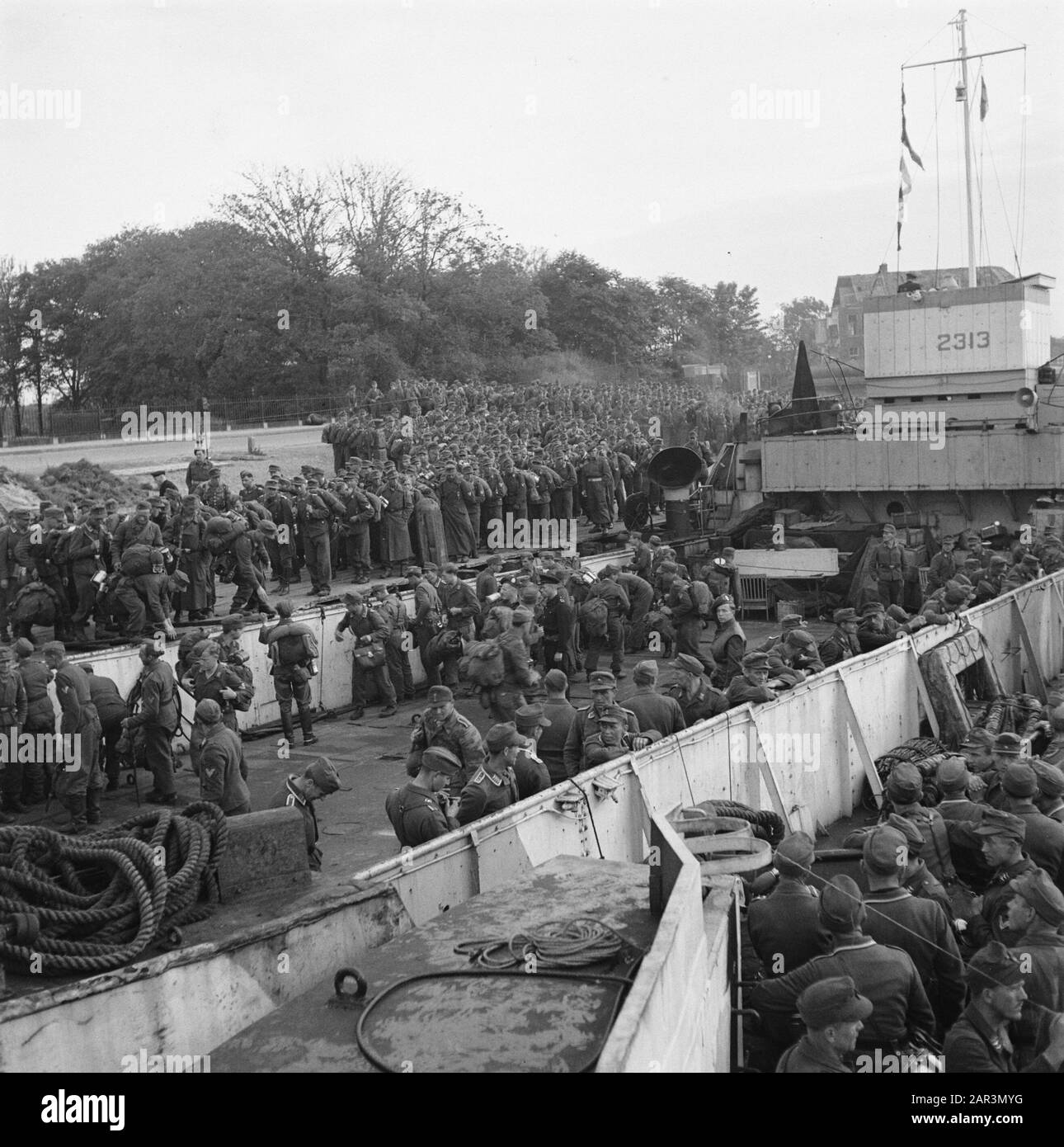 Capitulation: Den Helder  In Den Helder, the disarmed German soldiers are embarked in LCT boats for Harlingen, from where the long journey to the Heimat is made on foot. Date: June 1945 Location: Den Helder Keywords: prisoners of war, ships, World War II Stock Photo