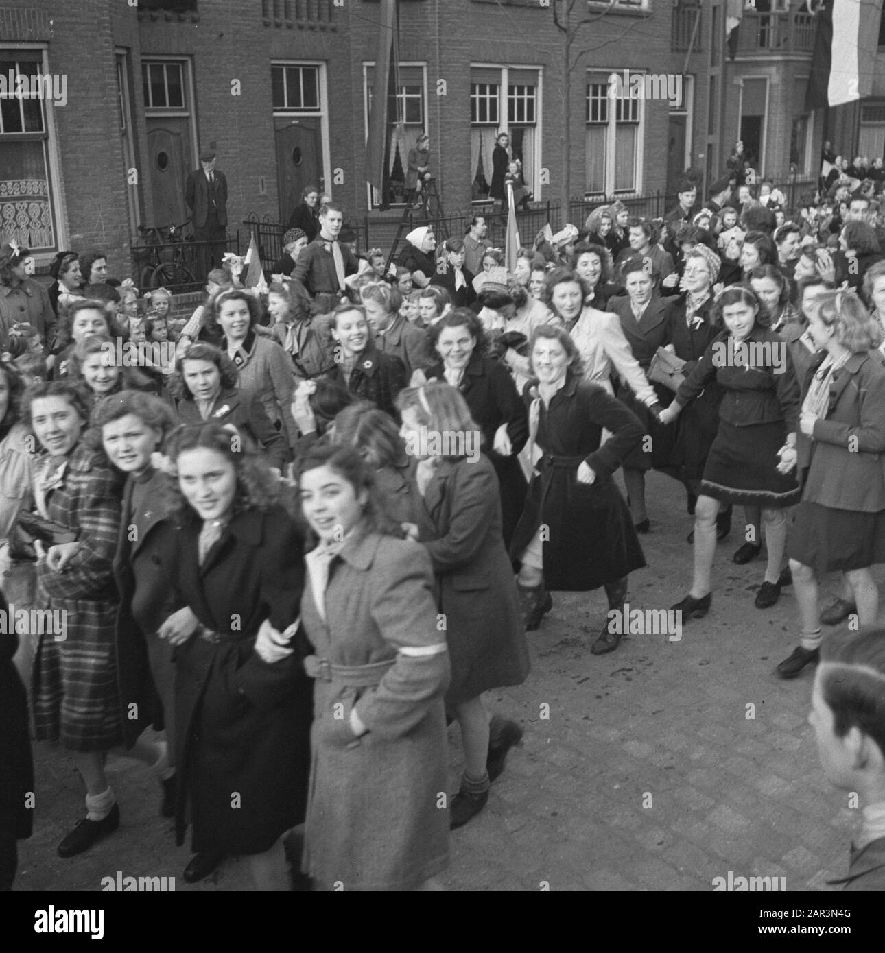 Tour of Queen Wilhelmina through liberated South Netherlands (Zeeland, Brabant and Limburg)  Young girls walk armed and hand in hand through a street Date: March 1945 Location: Zeeland Keywords: liberation, royal visits, girls, World War II Stock Photo