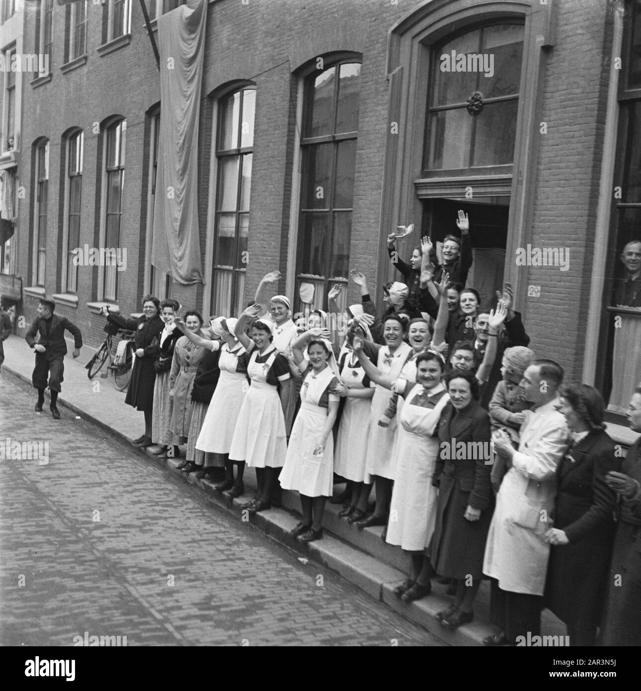 Tour of Queen Wilhelmina through liberated South Netherlands (Zeeland, Brabant and Limburg)  On her tour through Zeeland, Brabant and Limburg, Queen Wilhelmina arrives at half past eleven in Middelburg (photo caption Anefo). Waving nurses Date: March 15, 1945 Location: Middelburg, Zeeland Keywords: liberation, royal visits, World War II Stock Photo