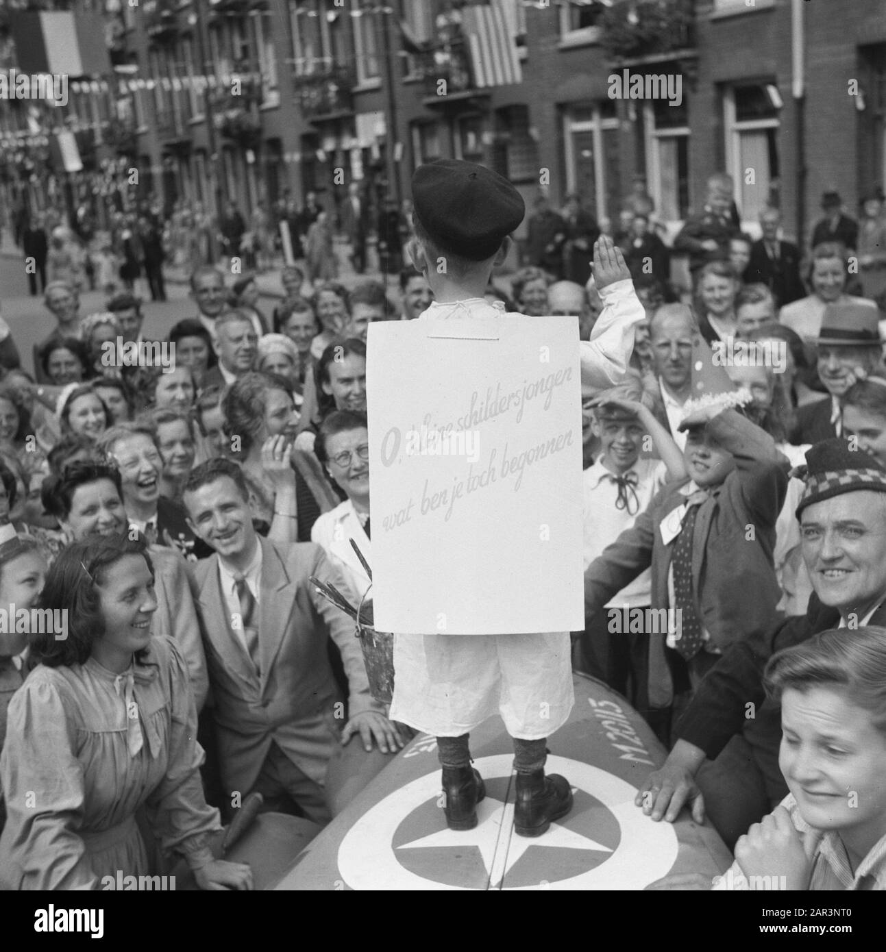 Folk entertainment in Amsterdam. Rep. of the various festivities after the liberation in the capital  [Boy dressed as the painter Hitler brings the Hitler greeting with on his back a sign showing O little painter boy what did you start] Date: June 28, 1945 Location: Amsterdam, Noord-Holland Keywords: Liberation festivals, World War II Stock Photo